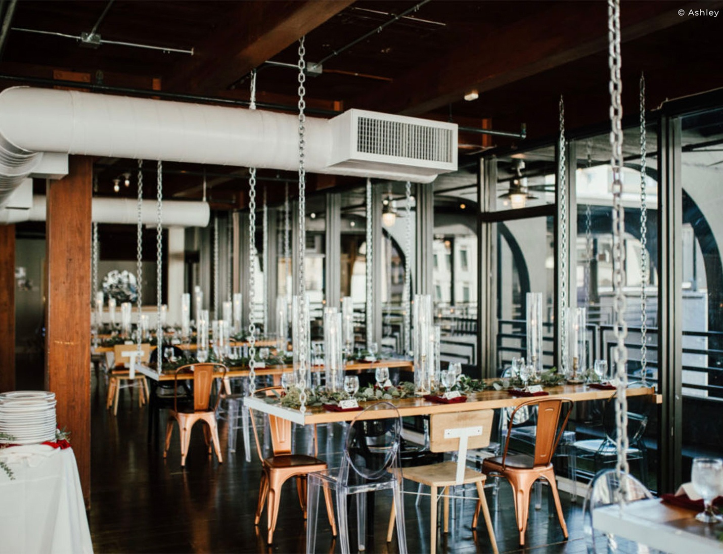 Industrial-style dining space at Station House with wooden tables, hanging chain accents, and modern metal chairs