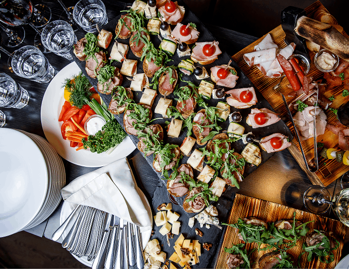 Assorted gourmet appetizers with cheese, meats, and bruschetta elegantly arranged on a catering table for an upscale event