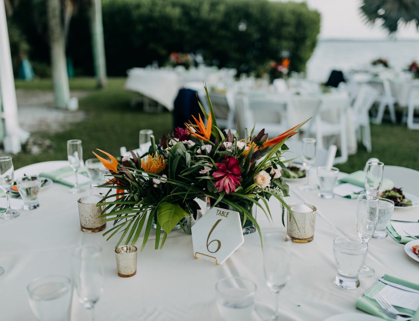 Wedding reception at Tampa Bay Watch featuring tropical floral centerpiece, table decor, and waterfront view