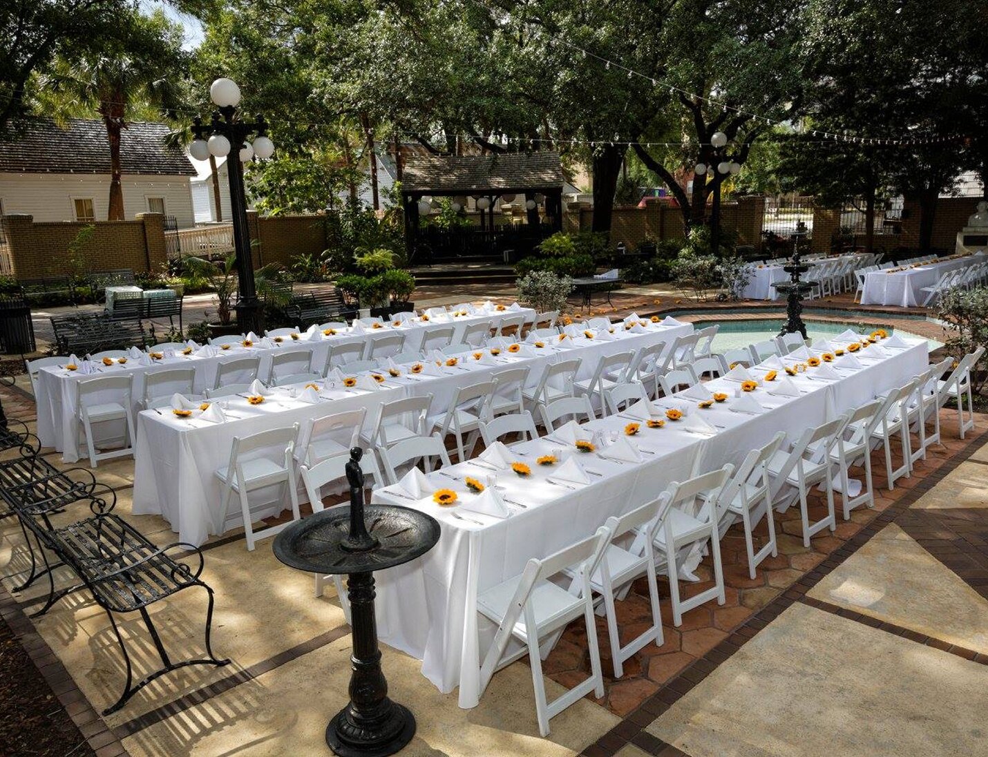 Courtyard reception at Ybor City Museum State Park with white tables, yellow flowers, and a fountain centerpiece
