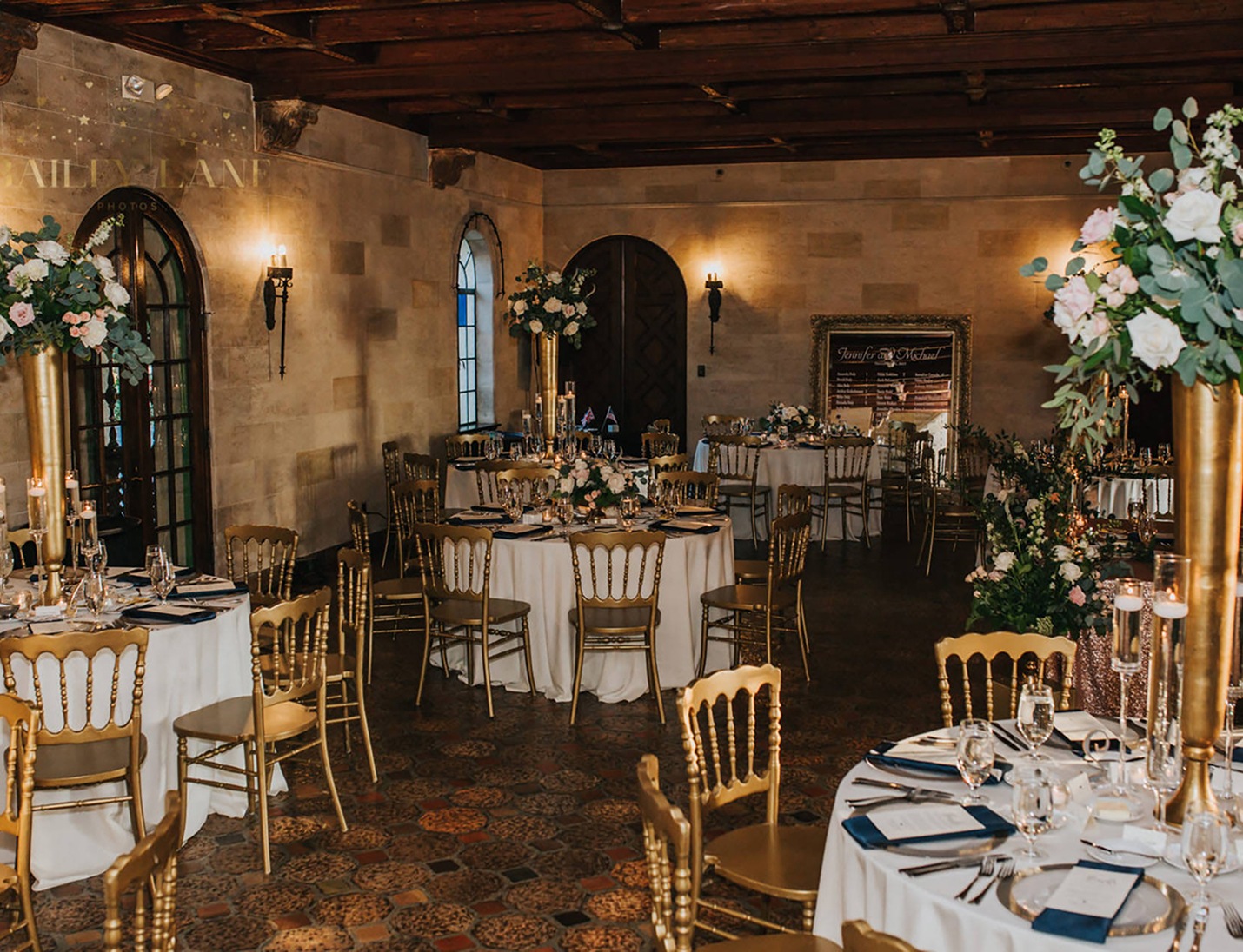 Elegant reception at Powel Crosley Estate with gold chairs, tall floral centerpieces, and warm candlelight ambiance