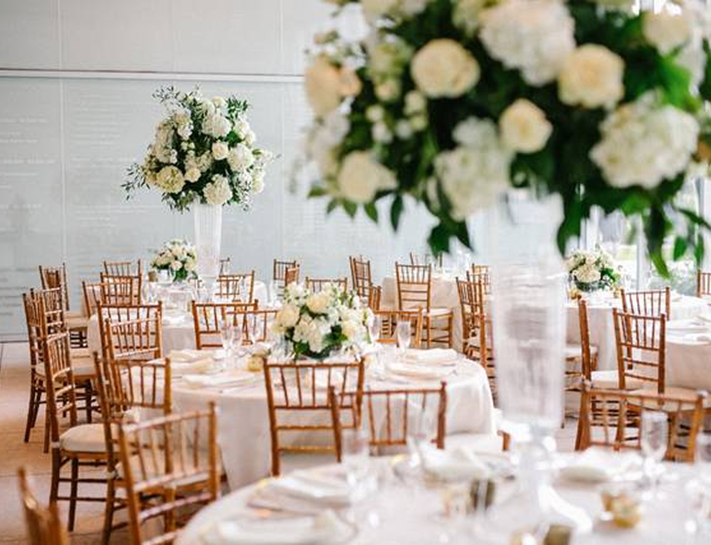 Elegant wedding reception at Tampa Firefighters Museum with tall white floral centerpieces and gold chiavari chairs