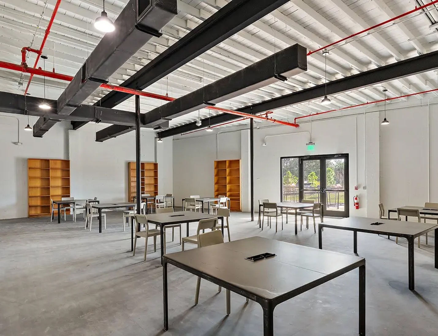 Industrial-style interior at The Factory St. Petersburg with exposed beams, metal tables, and bright natural light