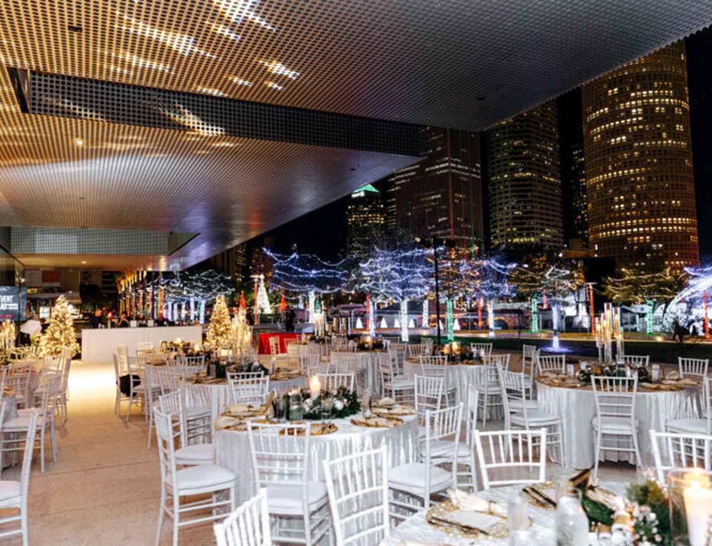Elegant evening event at Tampa Museum of Art with city skyline views, festive lights, and white-decorated round tables