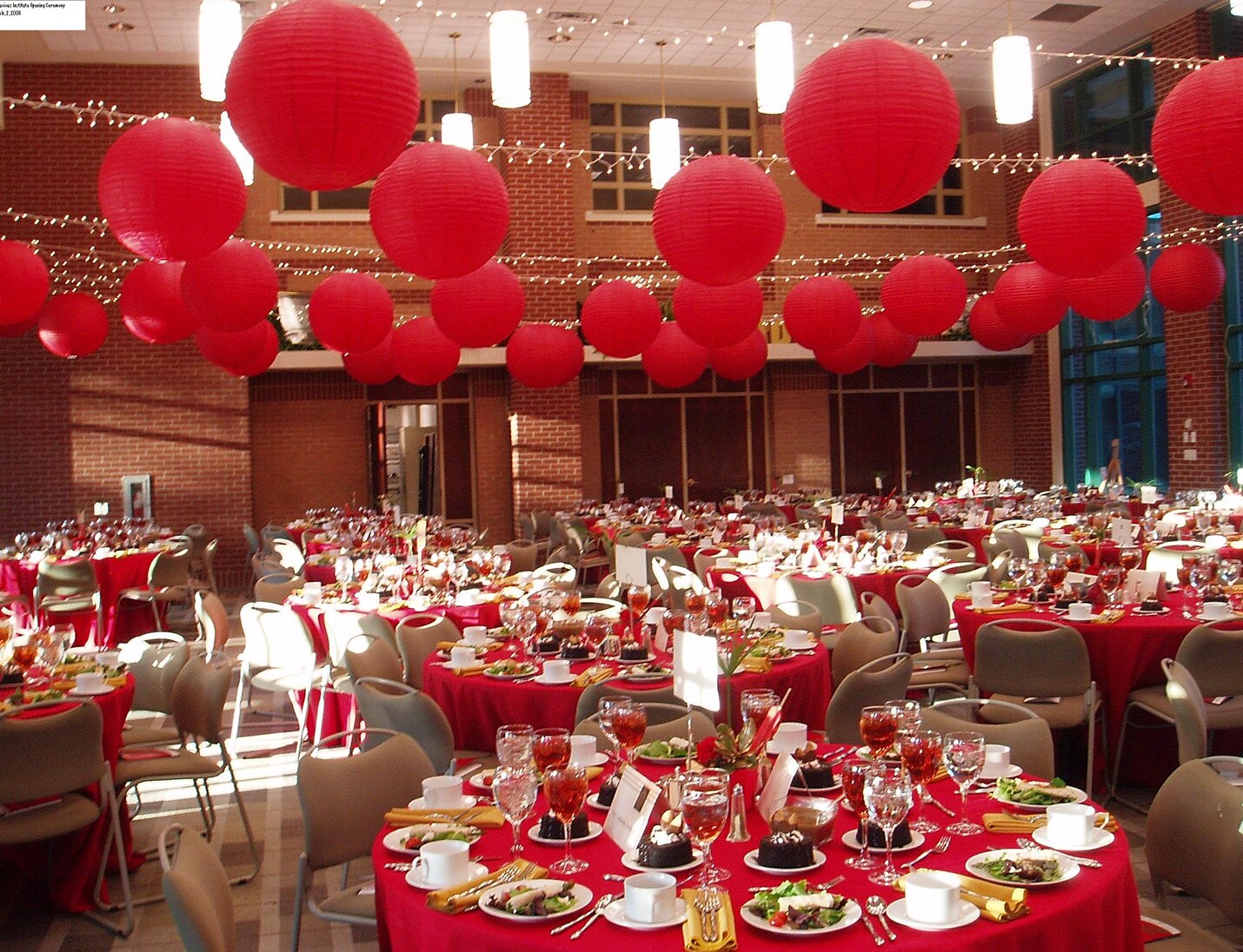 Event setup at USF Gibbons Alumni Center featuring red hanging lanterns, and festive lighting across a spacious hall