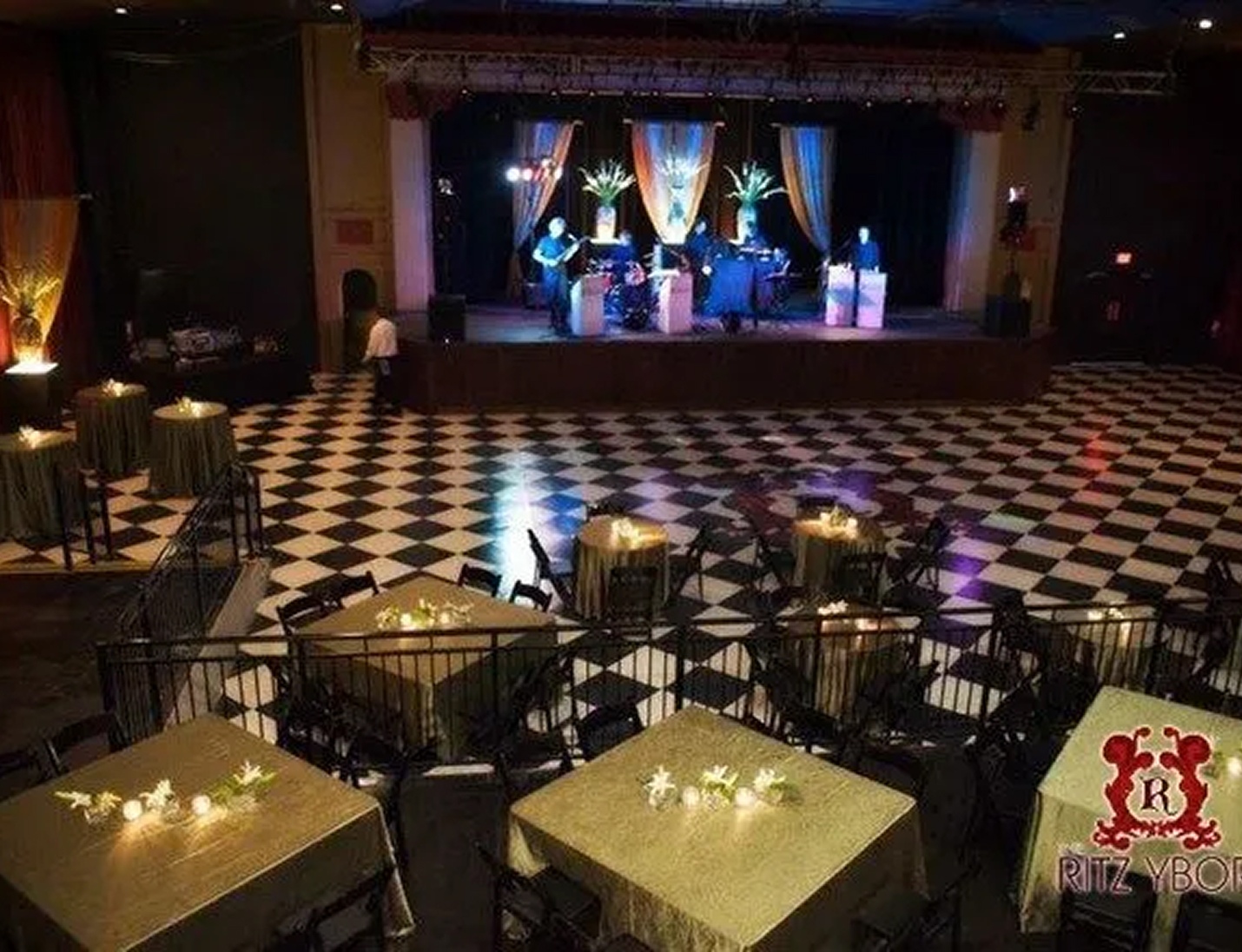 The Ritz Ybor event venue with black-and-white checkered floors, candlelit tables, and stage lighting for performances