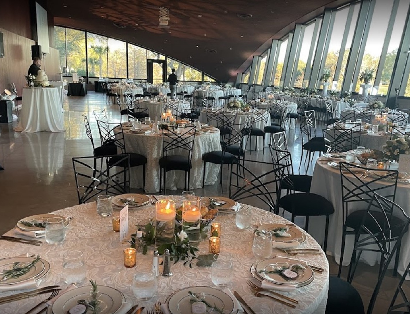 Elegant reception at Winter Park Events Center with round tables, candle centerpieces, and tall window views