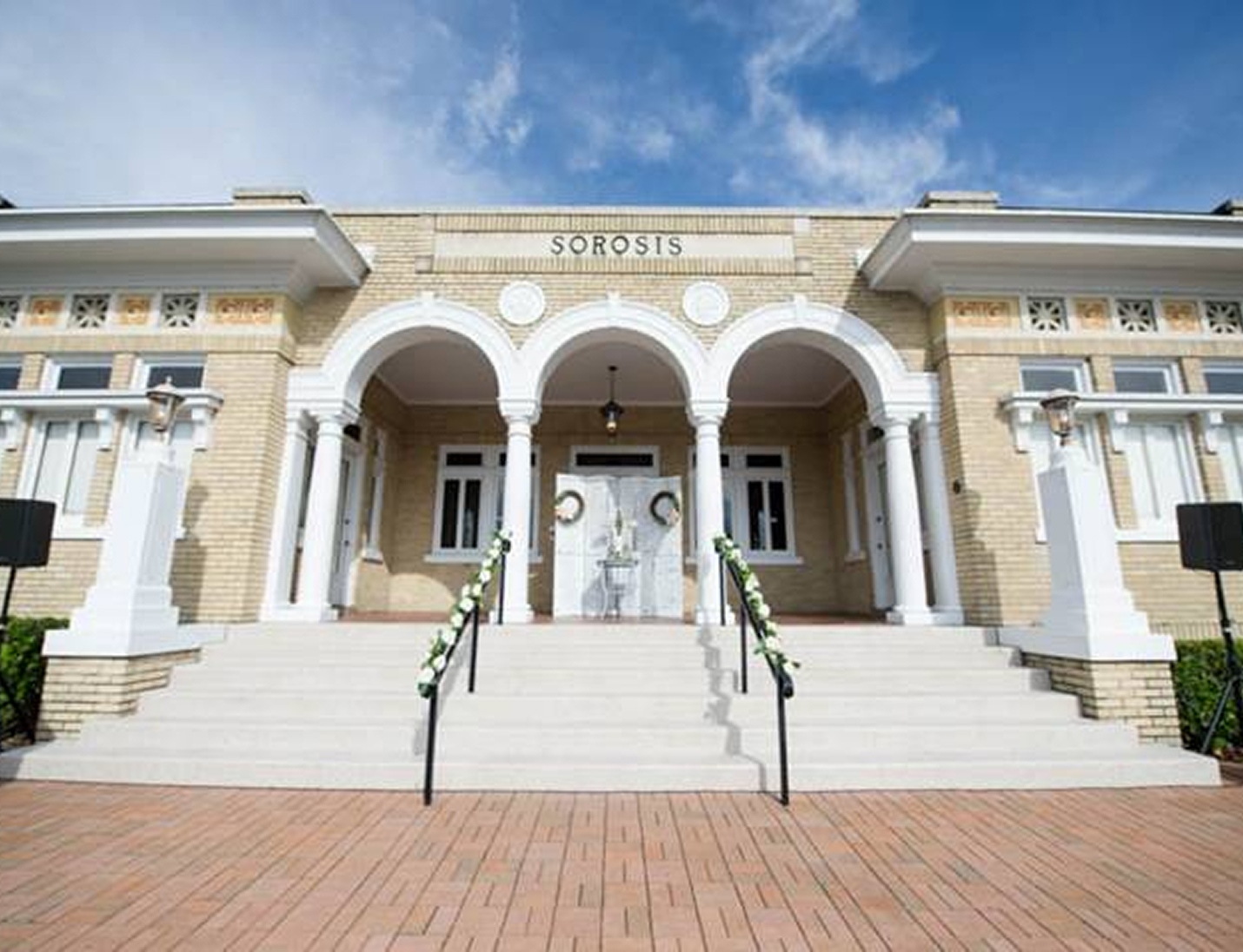 Junior League Sorosis Building exterior with grand white columns, arched entryway and wide staircase