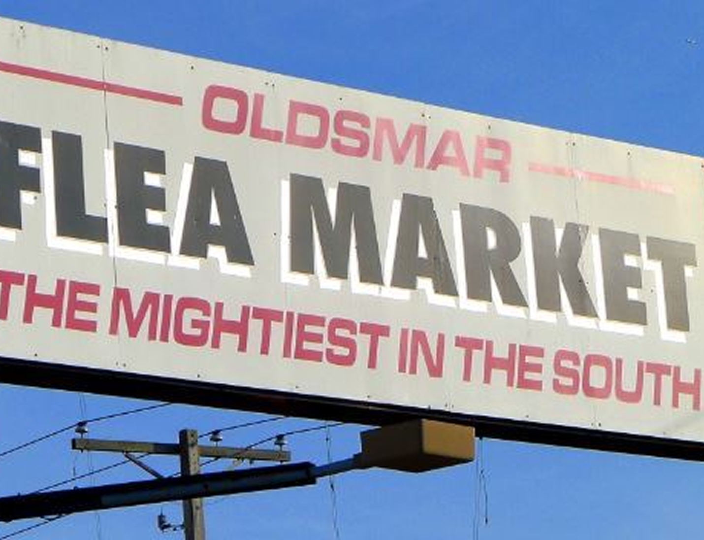 Entrance sign for The Venue at Oldsmar Flea Market, displaying bold lettering under a clear blue sky