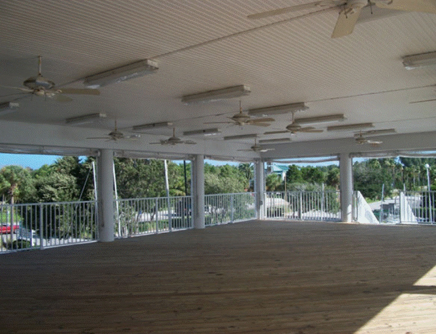 Open-air event deck at Clearwater Community Sailing Center with ceiling fans, wood flooring, and waterfront views