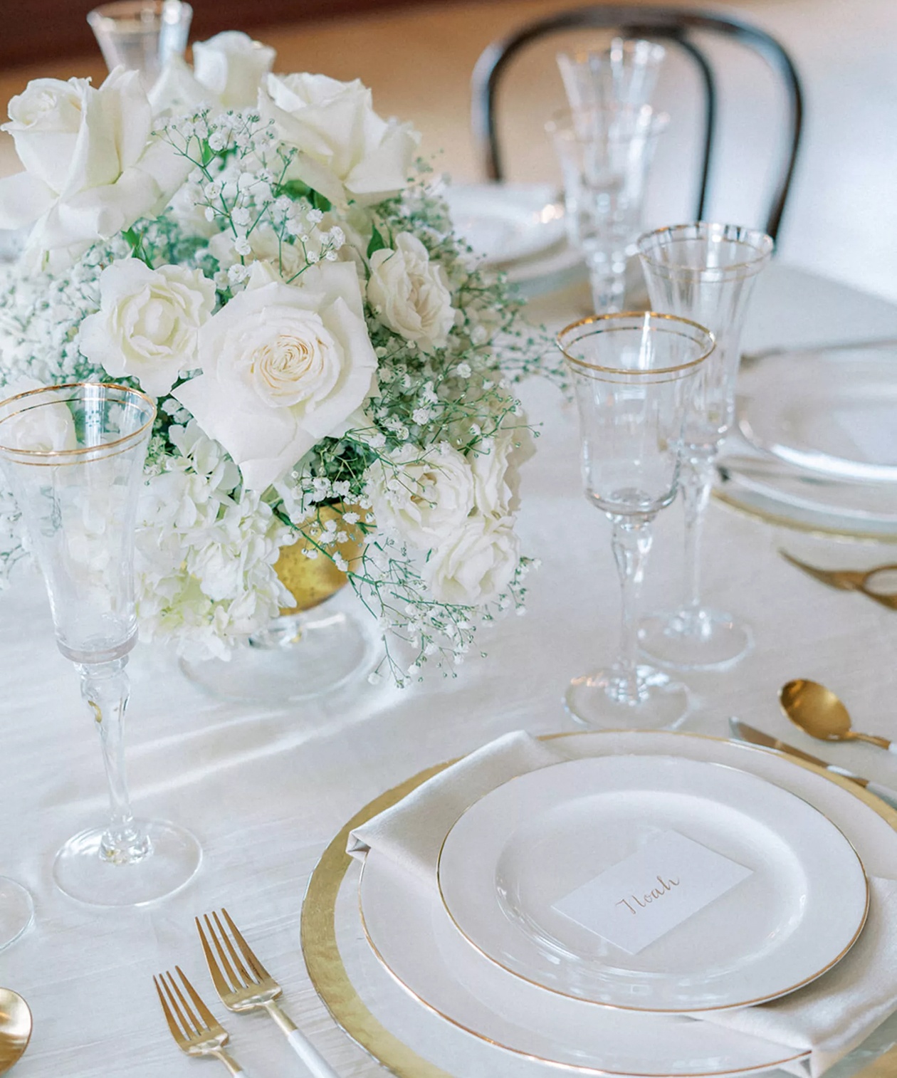 Elegant table setting at Centro Asturiano de Tampa with white roses, gold-rimmed glassware, and soft white linens