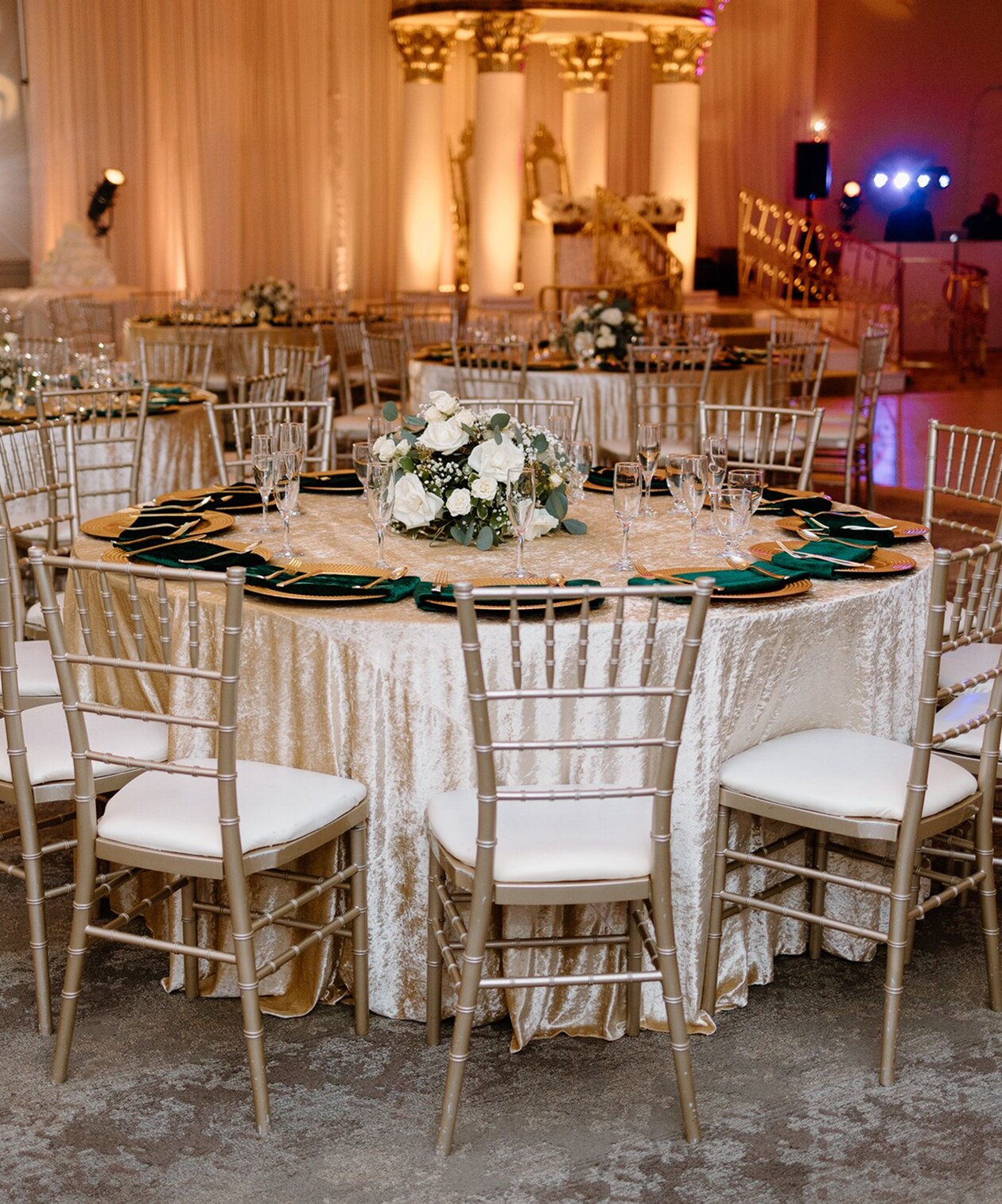 Elegant reception setup at Holy Trinity Reception Center with gold chairs, ivory linens, and white rose centerpieces