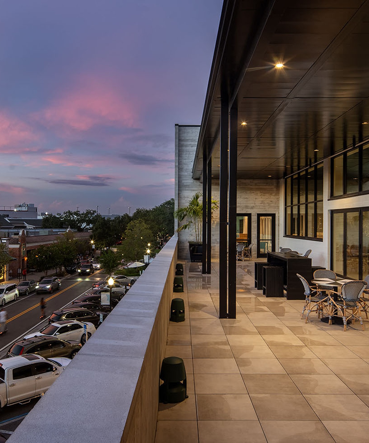 Rooftop terrace at Hyde House overlooking the street at sunset, with lounge seating and modern architectural design