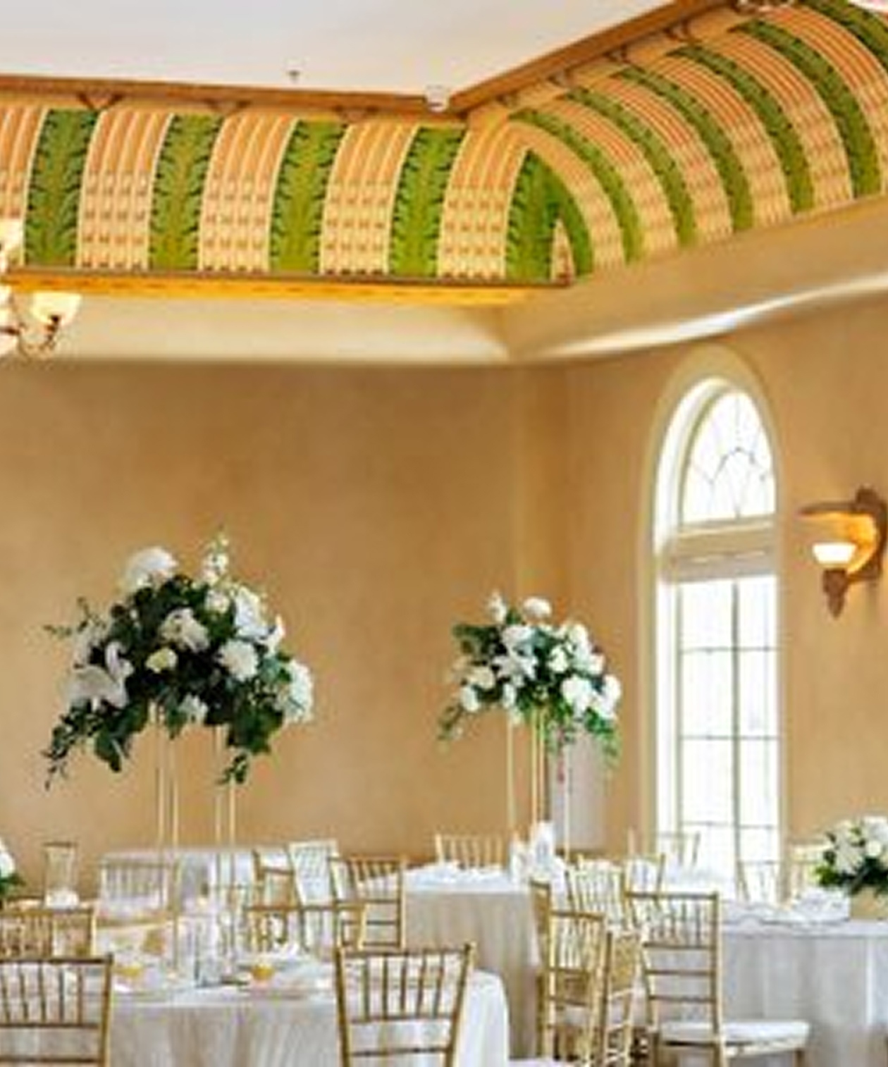 Elegant wedding reception at The Italian Club of Tampa with gold chairs, white linens, and tall floral centerpieces