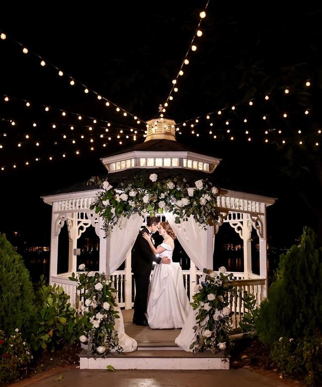 Romantic nighttime wedding at Davis Islands Garden Club gazebo, decorated with greenery and string lights