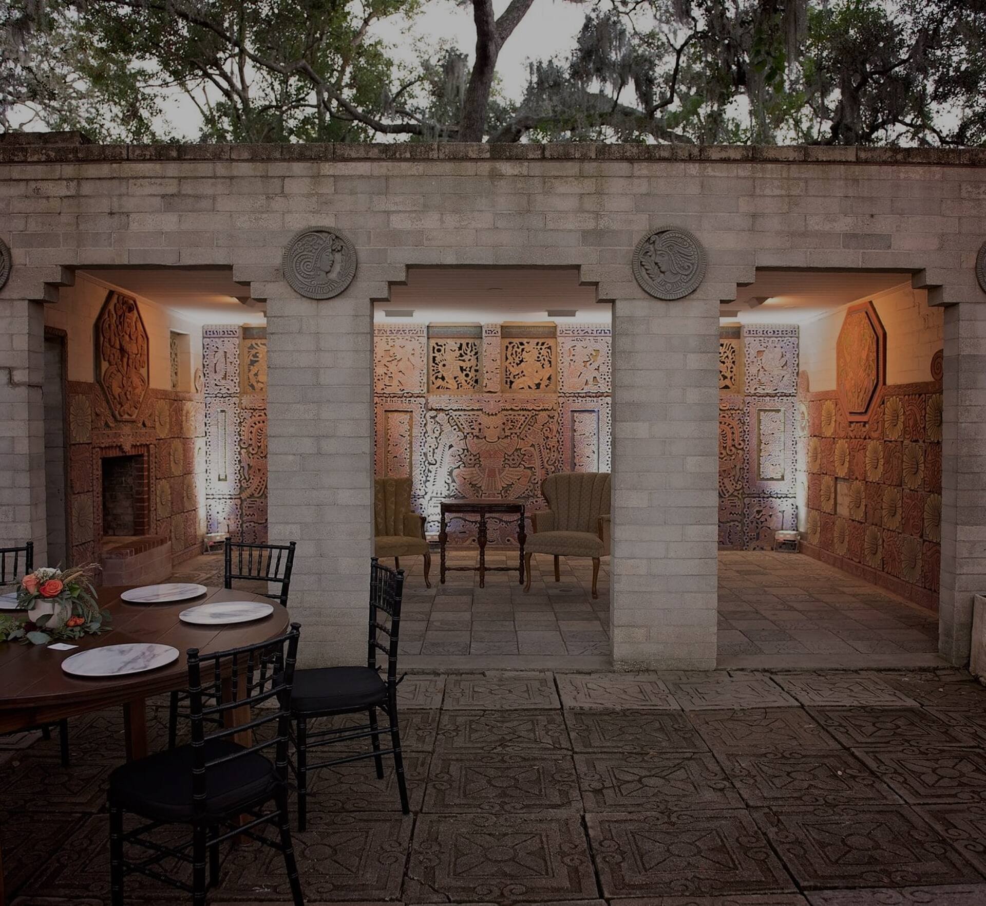 Art & History Museums - Maitland courtyard with carved stone walls, cozy lounge seating, and intimate event setup.