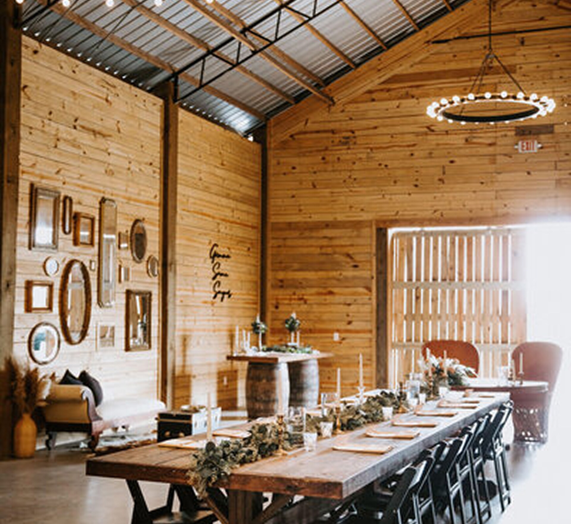 Rustic barn-style reception setup at Lovelock Ranch with long wooden tables, greenery centerpieces, and wooden walls