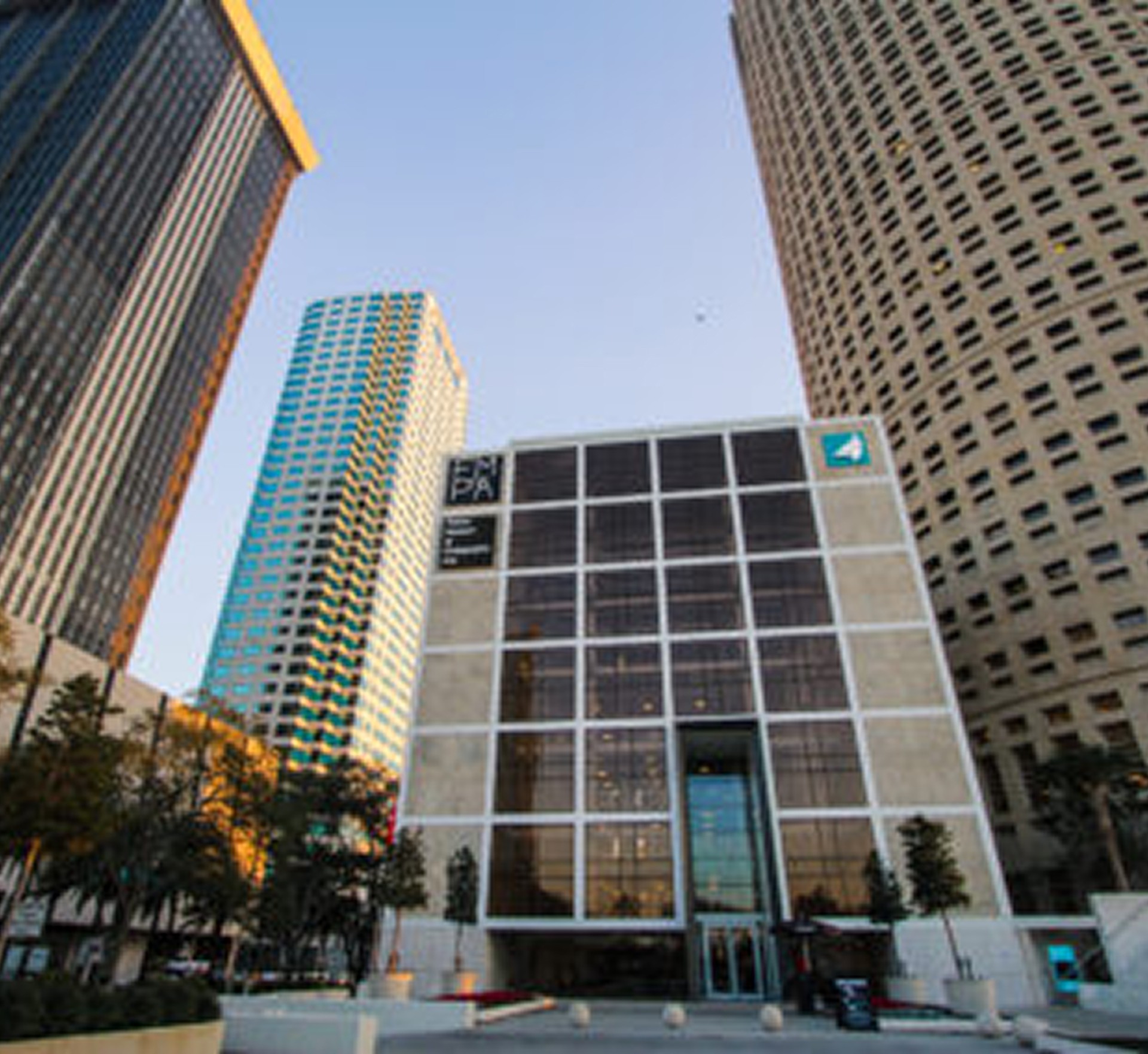 Exterior of the Tampa Museum of Art, surrounded by tall downtown skyscrapers under a clear sky